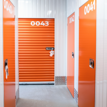 Blick auf ein Rolltor und Türen zu Boxen beim Selfstorage Lagerlöwe